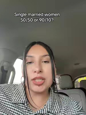 A woman with dark hair and light skin is recording a video inside a car. She is wearing a black and white checkered pattern shirt and large hoop earrings. The caption is set above her head.
