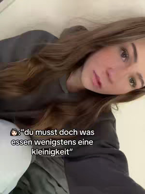 A young woman with long brown hair leans toward the camera, her expression serious. The background is a muted white, and text overlays at the bottom provide additional context.