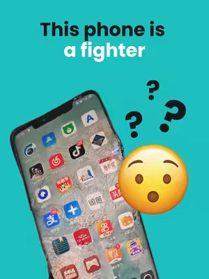 The image showcases a damaged smartphone with a cracked screen, prominently featuring a vibrant cyan background behind it. Overlaid are text elements, including "This phone is a fighter" in bold white lettering indicating that the phone is durable. Emojis like question marks and an open-mouthed surprised face enhance the expression. The phone screen itself displays numerous app icons, suggesting modern smartphone functionality.