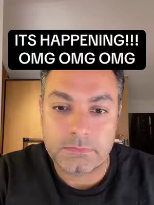 A man with short hair and a goatee is centered in the frame, looking downwards with a neutral expression. Above his head, a black rectangular banner displays white text: "ITS HAPPENING!!!" followed by the repeated phrase "OMG OMG OMG."