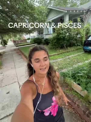 A woman is walking down a sidewalk with townhouses and green trees in the background. Text overlay states 'Capricorn & Pisces'.
