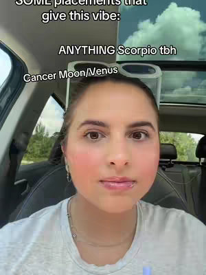 A woman with light skin, rosy cheeks, and light-colored hair is centered in the frame of the video. She is positioned inside a car, with seat in the background. Text overlays identify the subject as astrology insights.