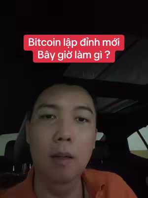 A selfie-style video cover shot from inside a car. The main focus is a medium shot of a man with a neutral expression, centered in the frame. Above him, a red rectangular text box displays Vietnamese text. The background shows car interior details and a glimpse of the outside environment.