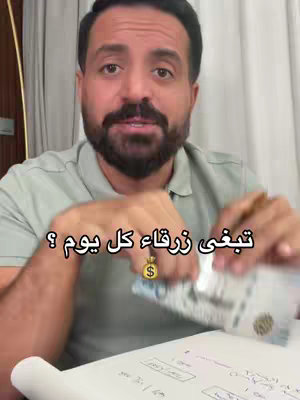 A man with a beard is holding a wad of Saudi Riyal banknotes and showing them to the camera. The man has a neutral expression and is in front of a cluttered background with a notepad on a table. Text overlayed reads "تبغى ٥٠٠ ريال كل يوم ?" (Want 500 Riyals every day?)