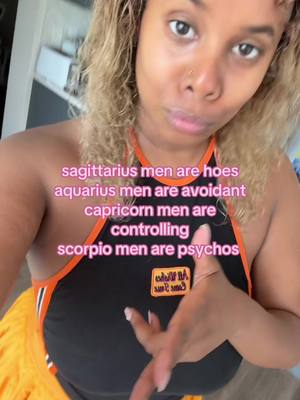 A selfie-style video cover features a woman with light brown skin and blonde-highlighted curly hair, framed from the chest up. She wears a black tank top with orange trim and a small patch. Text overlays convey zodiac-related assertions.