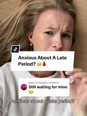 A young woman with blonde hair is lying down, looking concerned. Above her is a white text box with a TikTok logo, reading 'Anxious About A Late Period?' with a worried emoji and a drop of blood emoji. Underneath is a comment 'Still waiting for mine' and an anxious emoji.