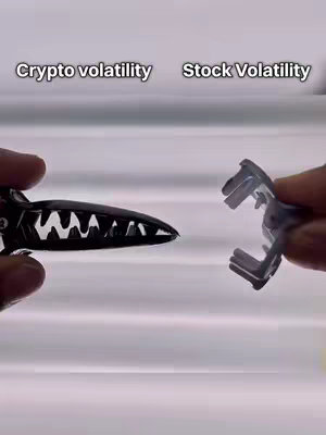 The image shows two hands holding different shaped, plastic hair clips against a vertically striped, blurred background. The clip in the left hand is black and has a segmented design. The clip in the right hand is silver with an open design. Text is overlaid above the hands, with the title 'Crypto volatility' above the black clip and 'Stock Volatility' above the silver one.