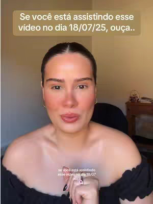A selfie-style shot featuring a fair-skinned woman looking directly at the camera with a neutral expression. Above her head is a tan text box with white text. She is wearing a black, off-the-shoulder top and has subtle makeup. The background is a blurred, neutral-toned interior.