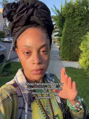 A woman with a head wrap and layered clothing stands on a sidewalk, gesturing with her hand while text overlays describe the photo.