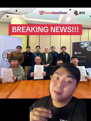 The cover image shows a group of individuals, likely signing documents, with text overlayed. The creator's face is in the foreground. Behind them, a banner reads 'BREAKING NEWS!!!'. The image involves a red bar with white text. The background includes people and logos. The composition centers on the event, which features figures holding papers and a smiling creator.
