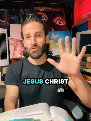 A man with a beard and long hair is shown, gesturing with his right hand, palm open. The background features artwork and a fan. Overlaid on the image is text.