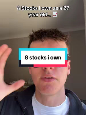 A young man in a black jacket and white shirt is centered in the frame, with text overlayed on the middle of his face. The background is a light gray wall. The overlay features the text "8 stocks i own" in a white font on a teal and black rectangle, and another text overlay above says "8 Stocks I own as a 27 year old...", with an upward pointing line chart symbol.
