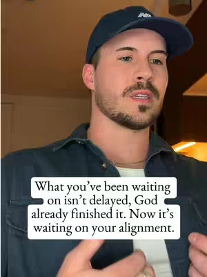 A man wearing a dark blue cap and shirt is centered in the frame, looking directly at the viewer. A text overlay in a white box is positioned below his face, containing a quote. The background is dimly lit.