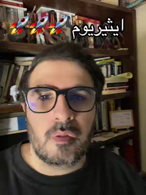 A man with a beard and glasses looks directly at the camera. Over his head, there is an Arabic text along with three rocket emojis.