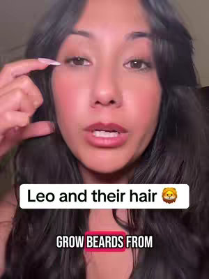 A close-up shot of a person pointing at their eye while talking. The image is well-lit with a soft focus. Across the bottom, superimposed text says, "Leo and their hair" with a lion emoji. Below that, there's another piece of text: "GROW BEARDS FROM".