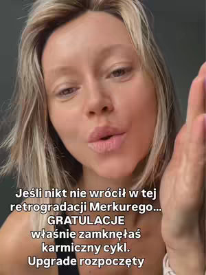 A close-up shot of a woman with blonde hair looking towards the camera. Text overlays are present at the bottom, and she has her hand up, possibly gesturing or talking.