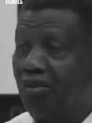 A grayscale, close-up shot of a man's face with a slightly sorrowful expression. The lighting is dim, and the man's features are defined by the contrast between light and shadow.