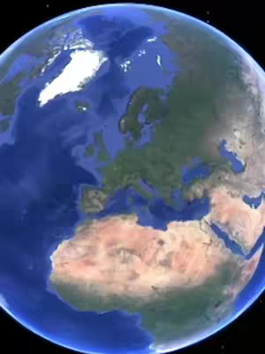 A depiction of earth with a blue ocean and continents in hues of green and brown. The image is set against a black background.