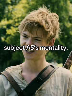 A medium shot of a young man with light brown hair, wearing a light-colored shirt, smiles with his head tilted slightly. Text overlays: "subject A5's mentality." The background is blurred a green foliage.
