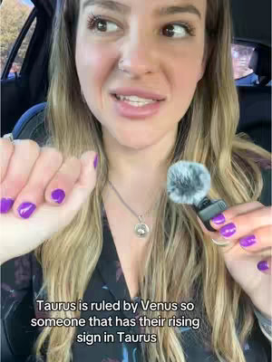 The image shows a woman in a car, with a microphone in her hand and a necklace. The text overlay on the image indicates that the video's topic is about astrology and birth charts. The woman is looking towards the side.