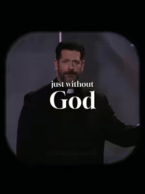 A man wearing a clerical collar stands formally looking towards the viewer, the background is dark but lit with lights.
