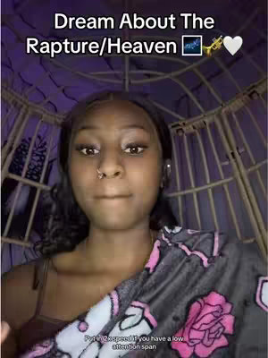 The cover image features a young woman in a selfie-style shot. It is an overall head and shoulders shot of a young woman with long dark hair and dark eyes, framed against a background that appears to be a decorative wicker structure with soft purple lighting. She is wearing a brown top and a floral blanket is draped over her shoulders. The text overlay at the image's top-left reads
"Dream About The
Rapture/Heaven"
and underneath the woman is a text overlay saying, “Putin 2x speed if you have a low attention span”.