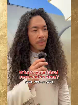 A man with long curly hair and a mustache is holding a small microphone in front of his mouth. Text overlay on the image asks "What's your ideal reservation time? 5PM, 7PM or 9PM."