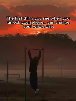 The cover image shows a silhouetted figure doing a pull-up on a bar at a park. The sky is filled with an orange and yellow sunset, and text at the top reads, "The first thing you see when you unlock your phone... can change your whole day."