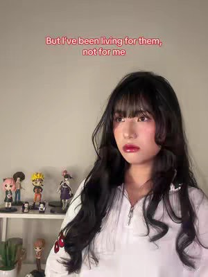 A person with long black hair and bangs is looking to the side with a somewhat sad look. Overlayed is a text hook in a red font.