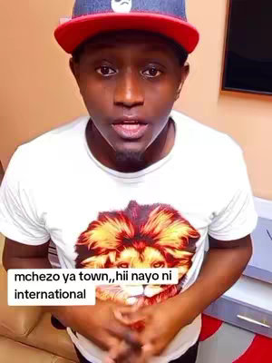 A man in a white t-shirt, red and blue cap is looking at the camera. Text bubble says 'mchezo ya town,, hii nayo ni international.'