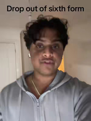 A young man is centered in the image, facing the camera and speaking. He is wearing a gray zip-up hoodie, under a white interior, hinting at him being either inside or near a door. The text overlayed on the top reads "Drop out of sixth form".