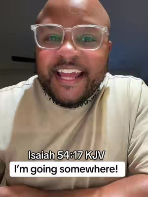 A close-up shot of a man with glasses smiling widely. He is bald, with a short beard and wearing clear-framed glasses. The background is blurred, and text overlays are placed at the bottom.