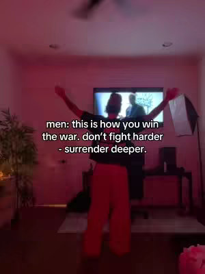 A person with their arms raised performs in front of a TV in a room lit in pink, with text overlayed on the image.