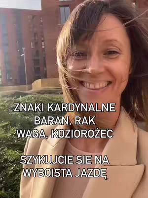 A woman with wind-blown hair smiles toward the camera, with text overlaid. Behind her, a building is visible under a cloudy sky.