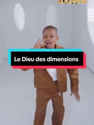 A young boy in a brown suit strikes a powerful singing pose against a bright backdrop, framed by a text overlay.