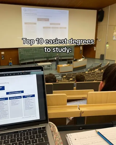 The cover image shows a lecture hall setting. A laptop sits open in the lower foreground, with a notebook and pencil beside it. The laptop screen displays a detailed chart or diagram. In the background, a projection screen shows a presentation, and a person is seen standing at a podium. The overall composition suggests a study or educational video. The hook text is overlaid, with the main focus being the subject 'Top 10 easiest degrees to study'.