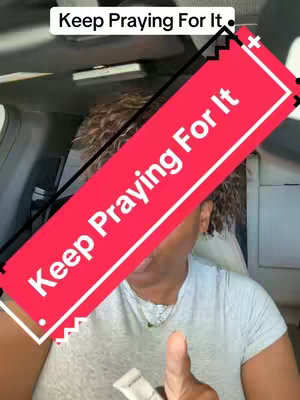 A person, likely in a car, is giving a thumbs-up. Across the image, there are overlapping red and black shapes with the text "Keep Praying For It" in white.