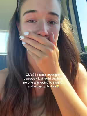 A close-up shot of a young woman, appearing emotional. She is covering her mouth with her right hand, and tears are visible in her eyes. The background is blurred, suggesting she might be inside a vehicle near a window. The lighting is natural, and the overall composition centers on her face, emphasizing her expression.
