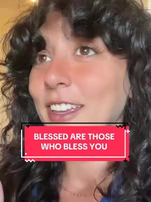 A woman with curly hair and a slight smile is the central focus. A translucent text box with a wavy design contains the text: 'BLESSED ARE THOSE WHO BLESS YOU' over a bright red background. The background shows a wall and the lighting is soft and natural.
