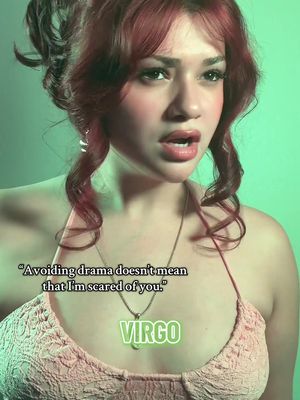 A person with red hair and makeup looks surprised. The background is a light green.