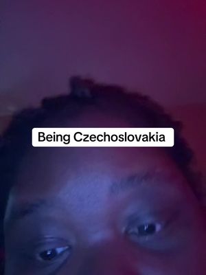 The cover image is a selfie with the top portion of a person's face visible, set against a gradient background of red and purple hues. The text overlay, "Being Czechoslovakia," is within a white rectangle at the top center. The person's face is partially visible, with the focus on the eyes and forehead. The lighting is dim, creating shadows across the face.