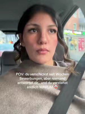 A woman in a car looking thoughtful, with text overlayed. She's wearing a light-colored sweater, with her hair styled. The background is blurred, suggesting movement.