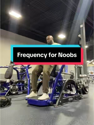 Shot in a gym, a man is sitting on a blue and black workout machine. Above him, a black and aqua colored banner overlay reads, "Frequency for Noobs."