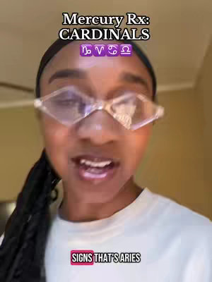 A selfie style video cover image with a dark-skinned woman with diamond-shaped glasses. Above her head are the words "Mercury Rx: CARDINALS" in a white, stylized font. Below that are four zodiac symbols. At the bottom, in a bright pink box, it says "SIGNS THAT'S ARIES".