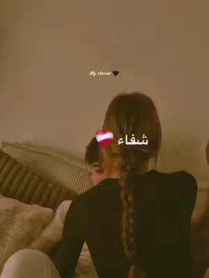 The cover image shows a close-up of two people cuddling. The woman's back is facing the camera with her hair in a braid. The man in the background is seen partly. In the foreground is a heart with the word "شفاء" superimposed. The color palette is warm, with a focus on beige and brown tones.