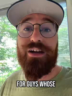 A close-up shot of a man with a full red beard, glasses, and a baseball cap. The background is blurred, but appears to be an outdoor window with green trees. The man has a slightly open mouth and seems to be talking. Text overlayed on the bottom in a white box reads 'FOR GUYS WHOSE'.