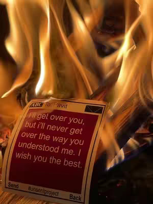 Image of a burning fire with a piece of paper in the flames. The paper is a mock-up of a text message with a goodbye message written on it.
