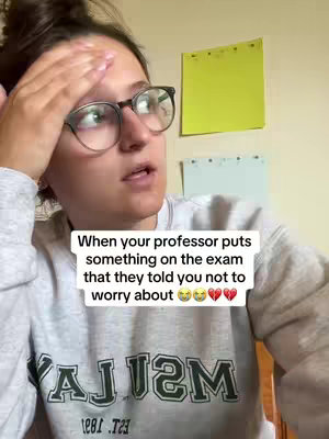 A woman with dark hair and glasses looks at the camera with a concerned expression, with a hand on her forehead. Overlay text about exam stress fills the bottom portion of the frame.