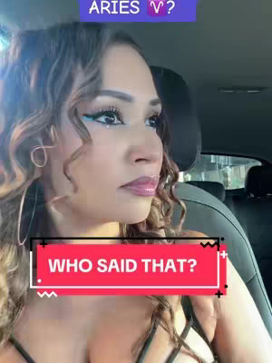 A woman in a car looks at the camera with slight concern. The frame is in the front seat of a car, with the back of the seat visible behind her. The focal point is her face with makeup, curly hair, and an overlay text box.