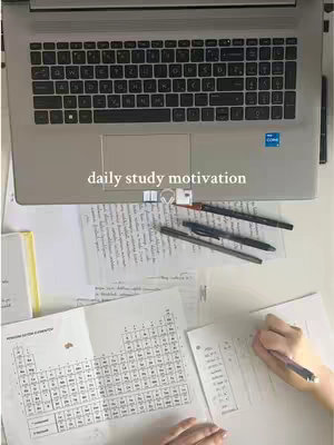 An overhead shot of a workspace with a laptop, papers, and pens, suggesting a study environment.